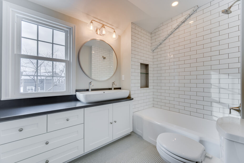 Updated Bathroom with white tile shower and black countertop